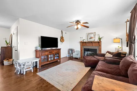 a living room with furniture a flat screen tv and a fireplace