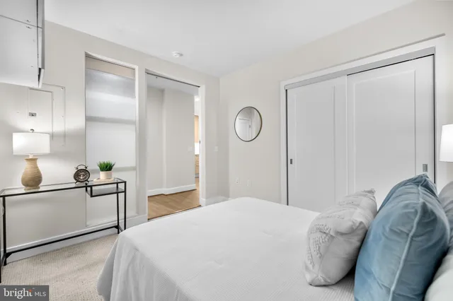 a bedroom with a bed and a lamp on dresser