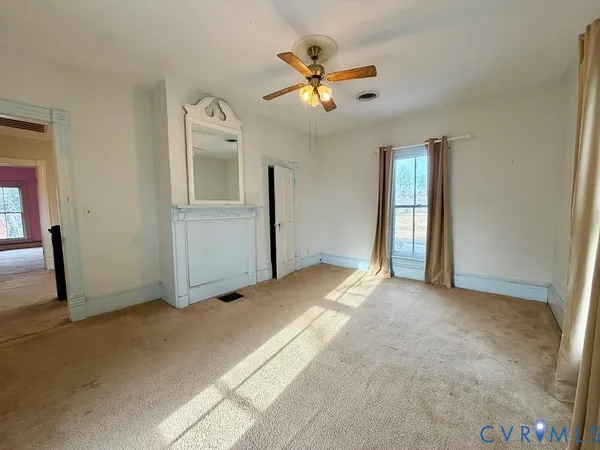 a view of a livingroom with a ceiling fan and window
