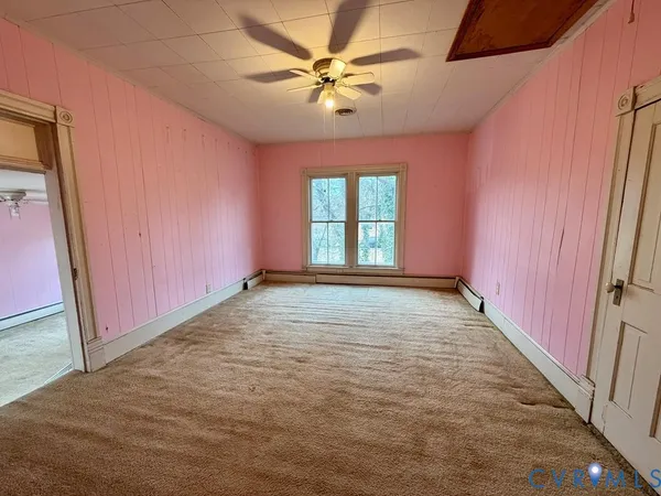 an empty room with windows and fan