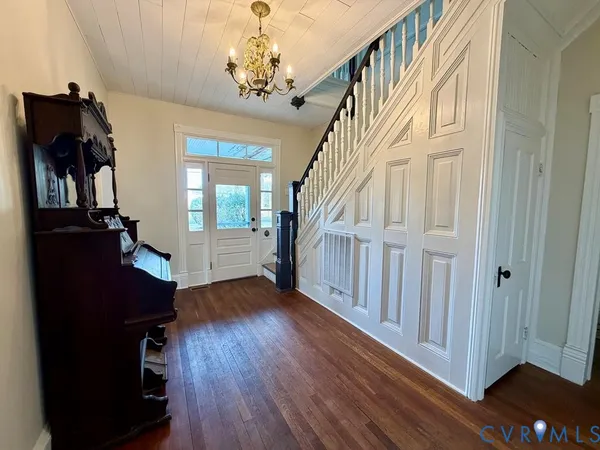 a view of a hallway with wooden floor and staircase