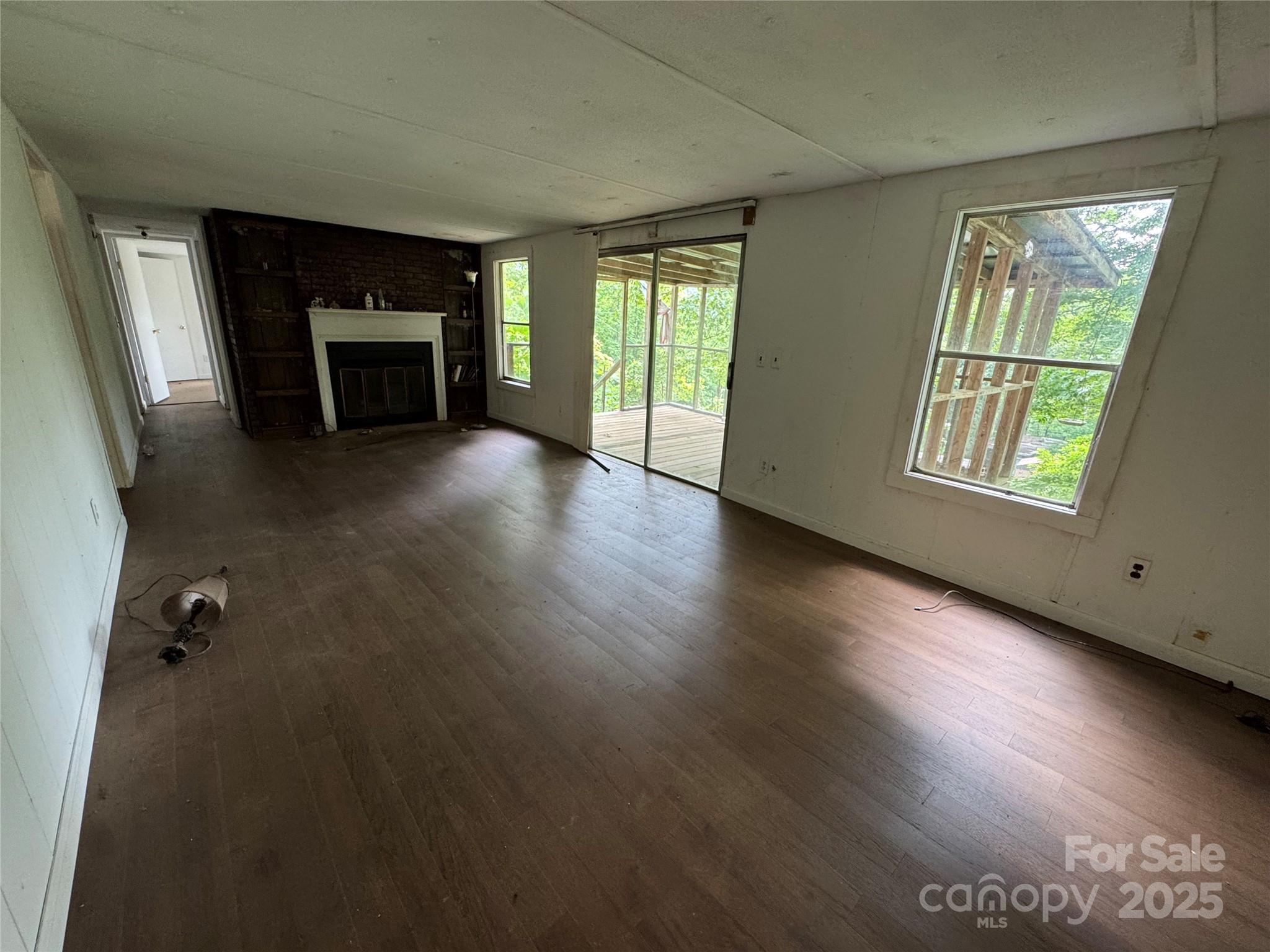 91 Keys Hill Road Almond, NC 28702 - Photo 18 of 19 an empty room with windows fireplace and wooden floor