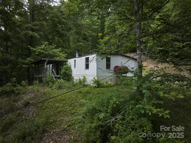 a front view of a house with a yard and tree