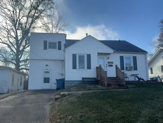 a front view of a house with a yard and outdoor seating