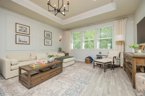 a bedroom with a large bed and a chandelier