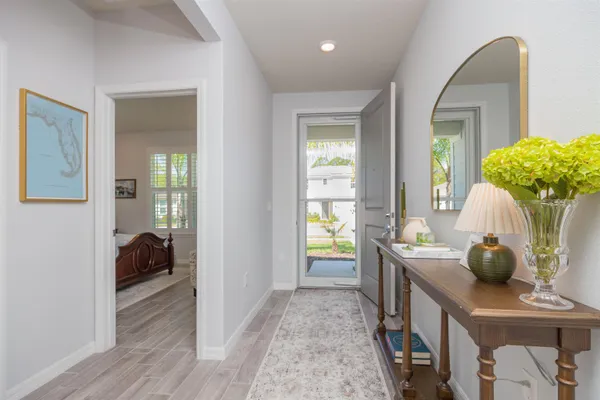 a kitchen with sink stove and white cabinets with wooden floor