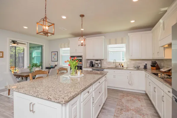 a kitchen with granite countertop a sink a counter top space appliances and cabinets