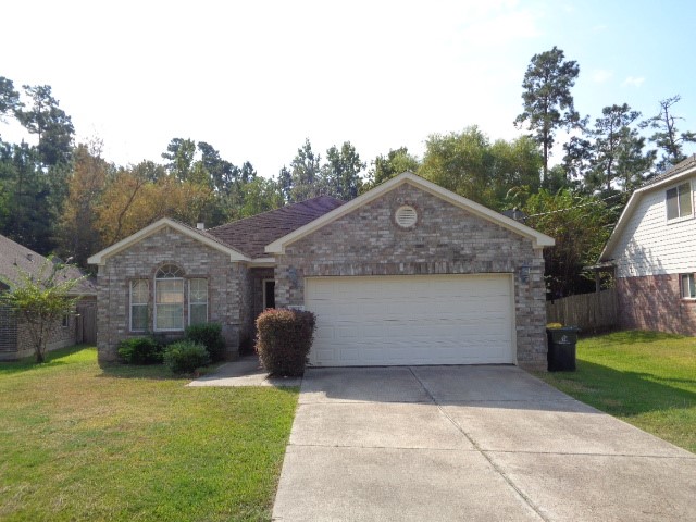 205 Maple Lane Conroe, TX 77304 - Photo 1 of 19 a front view of a house with garden