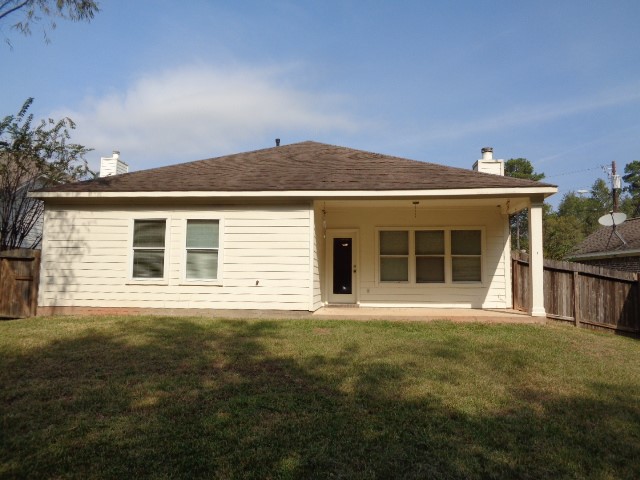 205 Maple Lane Conroe, TX 77304 - Photo 18 of 19 front view of a house with a garden