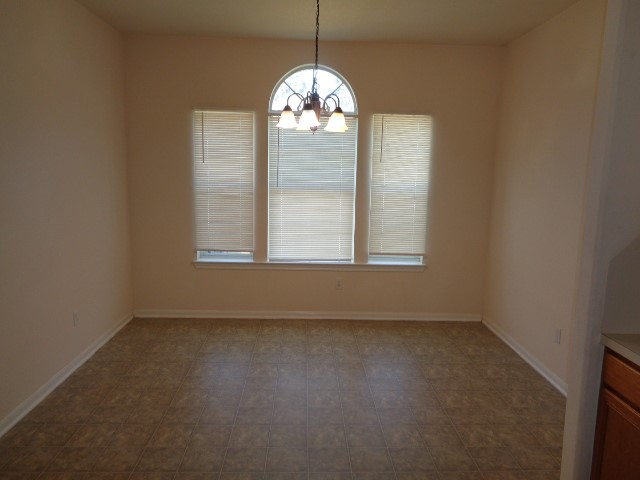 205 Maple Lane Conroe, TX 77304 - Photo 5 of 19 an empty room with windows chandelier fan and windows