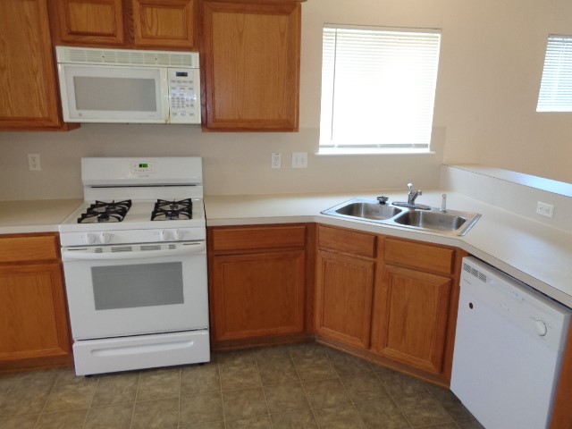 205 Maple Lane Conroe, TX 77304 - Photo 7 of 19 a kitchen with cabinets appliances a sink and a window