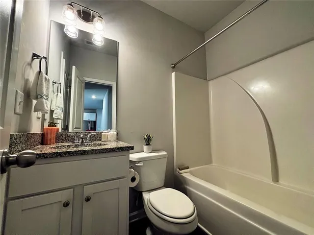 a bathroom with a granite countertop sink a mirror and shower