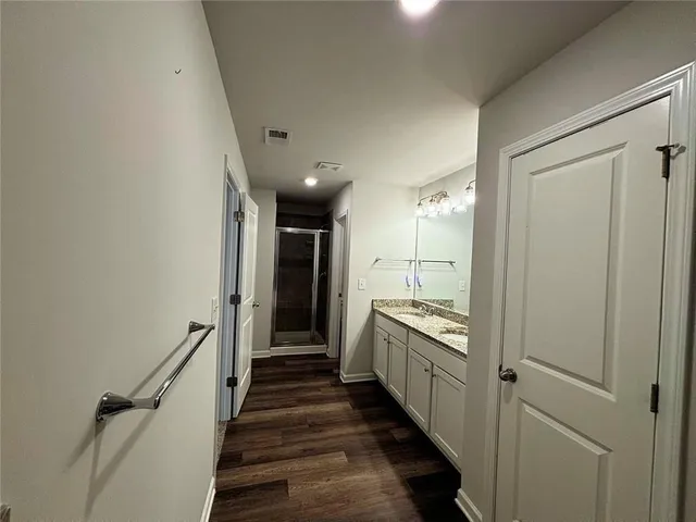 a bathroom with a granite countertop sink a large mirror a bathtub and shower