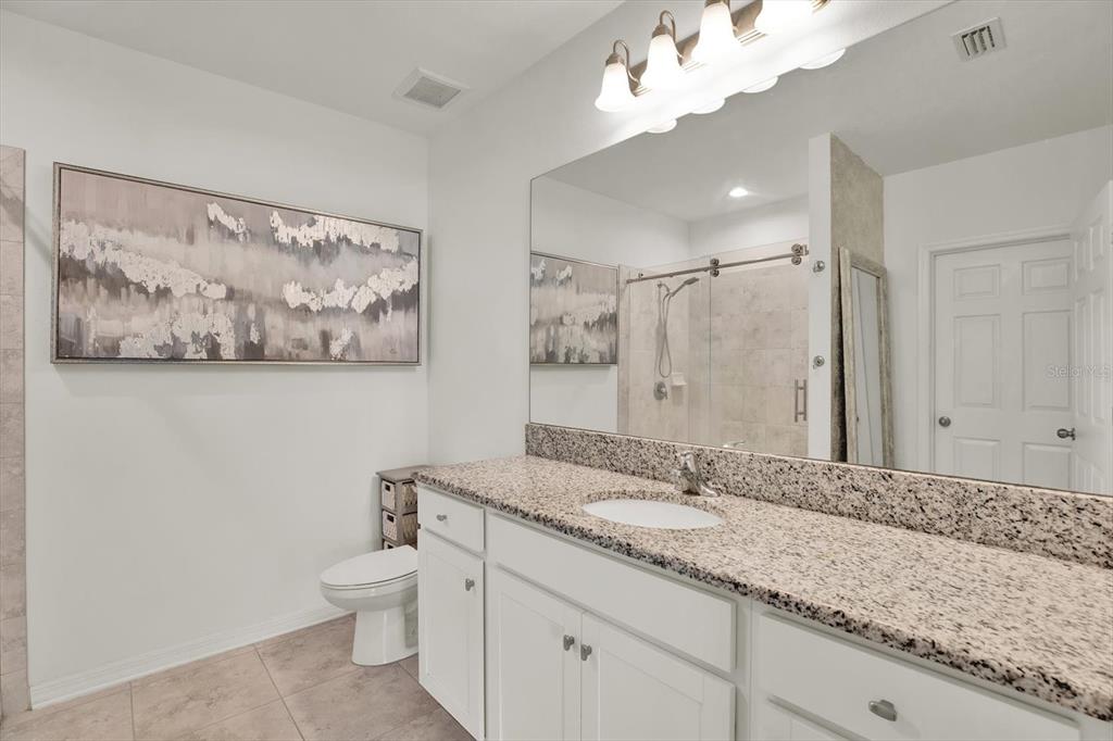 12103 Gothic Rd Spring Hill Spring Hill, FL 34610 - Photo 16 of 44 a bathroom with a granite countertop sink mirror vanity and toilet