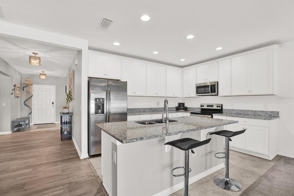 12103 Gothic Rd Spring Hill Spring Hill, FL 34610 - Photo 2 of 44 a kitchen with stainless steel appliances granite countertop a sink a stove a refrigerator and cabinets