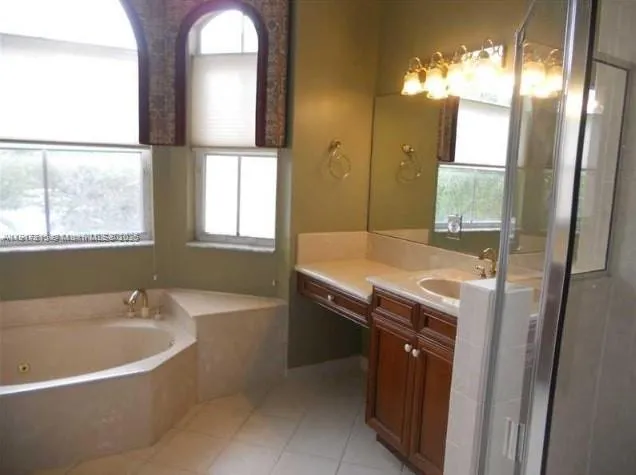 a bathroom with a tub sink and mirror
