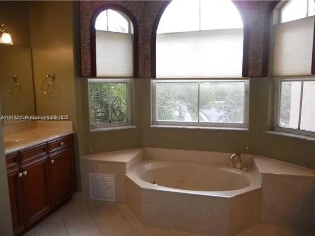 a white bath tub sitting in a bathroom next to a window