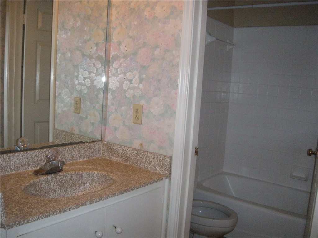 2529 Rio Grande Street, Unit 57 Austin, TX 78705 - Photo 17 of 20 a bathroom with a granite countertop bathtub and toilet