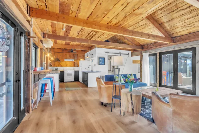 a living room with furniture a flat screen tv and windows