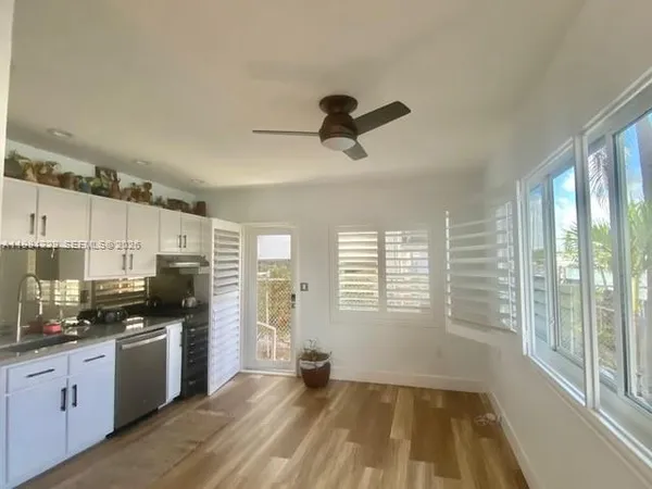 a kitchen with granite countertop a stove a sink a refrigerator a window and cabinets