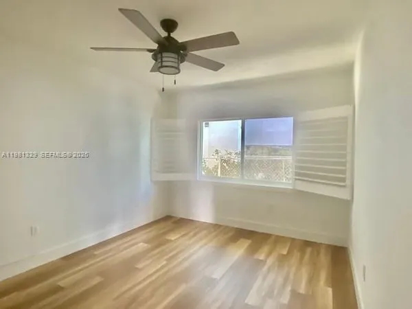 a view of empty room with wooden floor