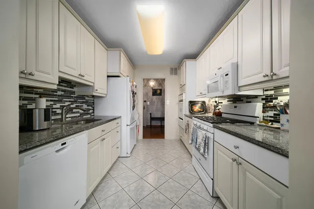 a kitchen with stainless steel appliances granite countertop a stove a sink and a refrigerator