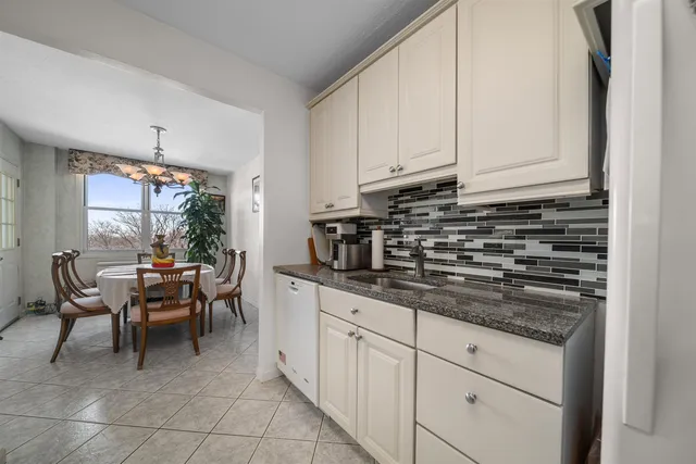 a kitchen with granite countertop white cabinets and stainless steel appliances