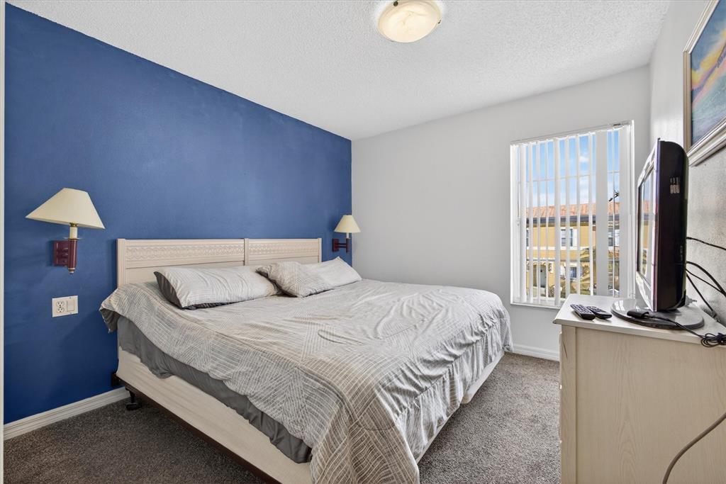 1066 Park Ridge Circle Kissimmee, FL 34746 - Photo 35 of 49 a bedroom with a bed table flat screen tv and window