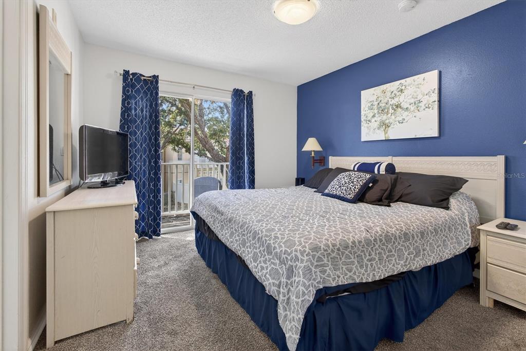 1066 Park Ridge Circle Kissimmee, FL 34746 - Photo 42 of 49 a bedroom with a bed a mirror on dresser and a large window