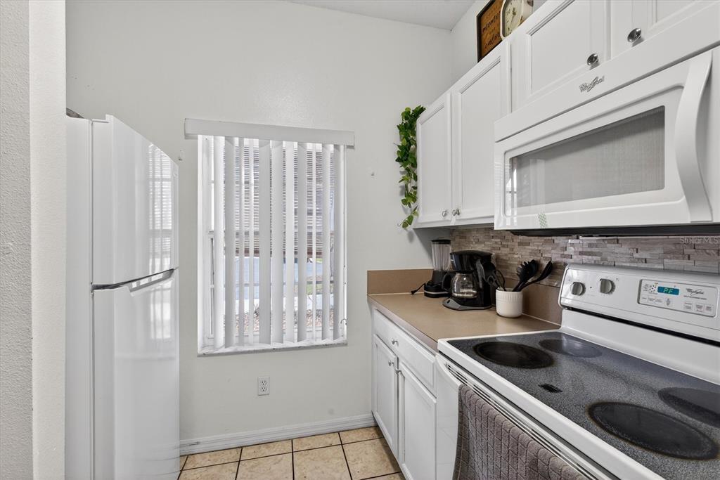 1066 Park Ridge Circle Kissimmee, FL 34746 - Photo 45 of 49 a kitchen with stainless steel appliances granite countertop a sink and a microwave