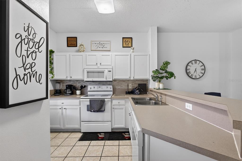 1066 Park Ridge Circle Kissimmee, FL 34746 - Photo 49 of 49 a kitchen with a sink a stove top oven and cabinets