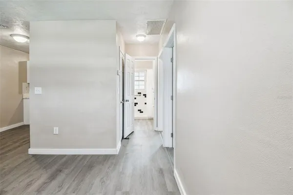 a view of a hallway with wooden floor