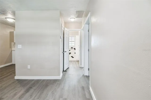 a view of a hallway with wooden floor