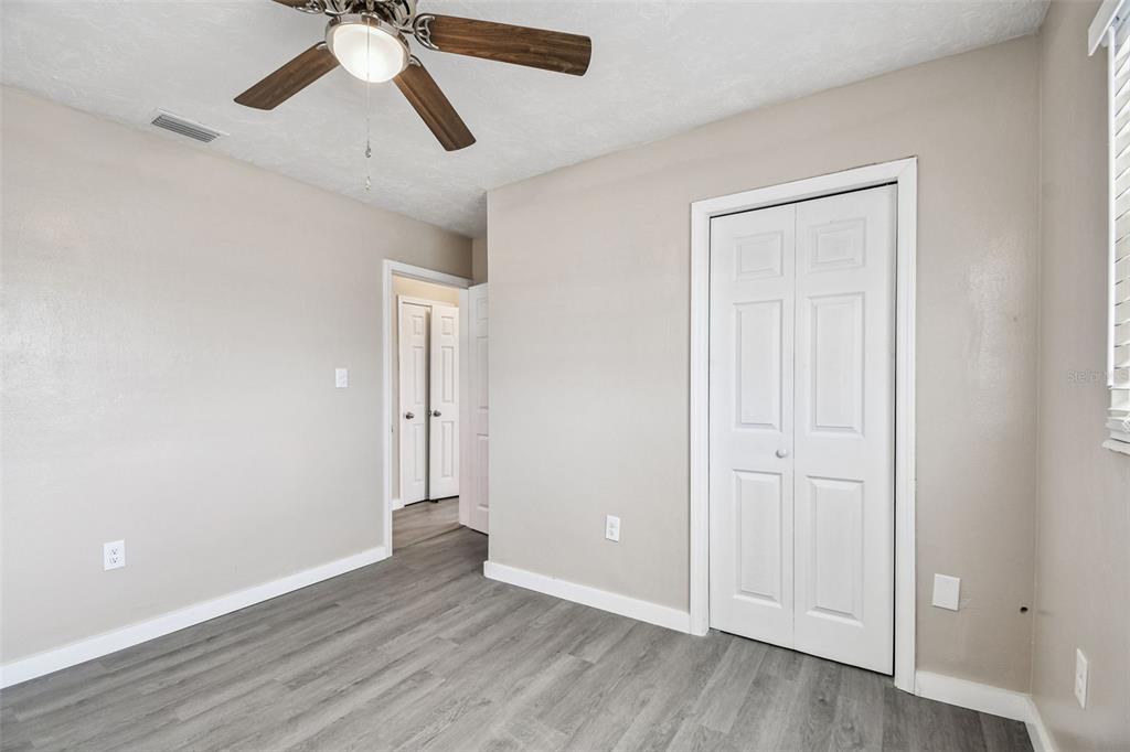337 4th Street West, Unit A Palmetto, FL 34221 - Photo 15 of 25 an empty room with wooden floor ceiling fan and windows