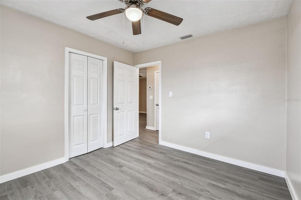 337 4th Street West, Unit A Palmetto, FL 34221 - Photo 17 of 25 an empty room with wooden floor fan and windows