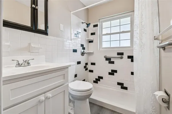 a bathroom with a sink a toilet and shower