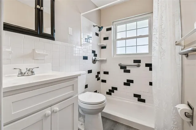 a bathroom with a sink a toilet and shower