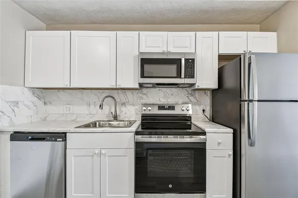 a kitchen with a sink stove and refrigerator