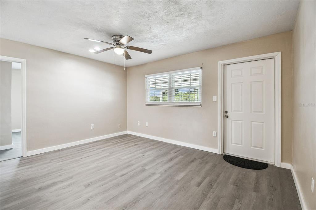 337 4th Street West, Unit A Palmetto, FL 34221 - Photo 22 of 25 an empty room with wooden floor chandelier fan and windows