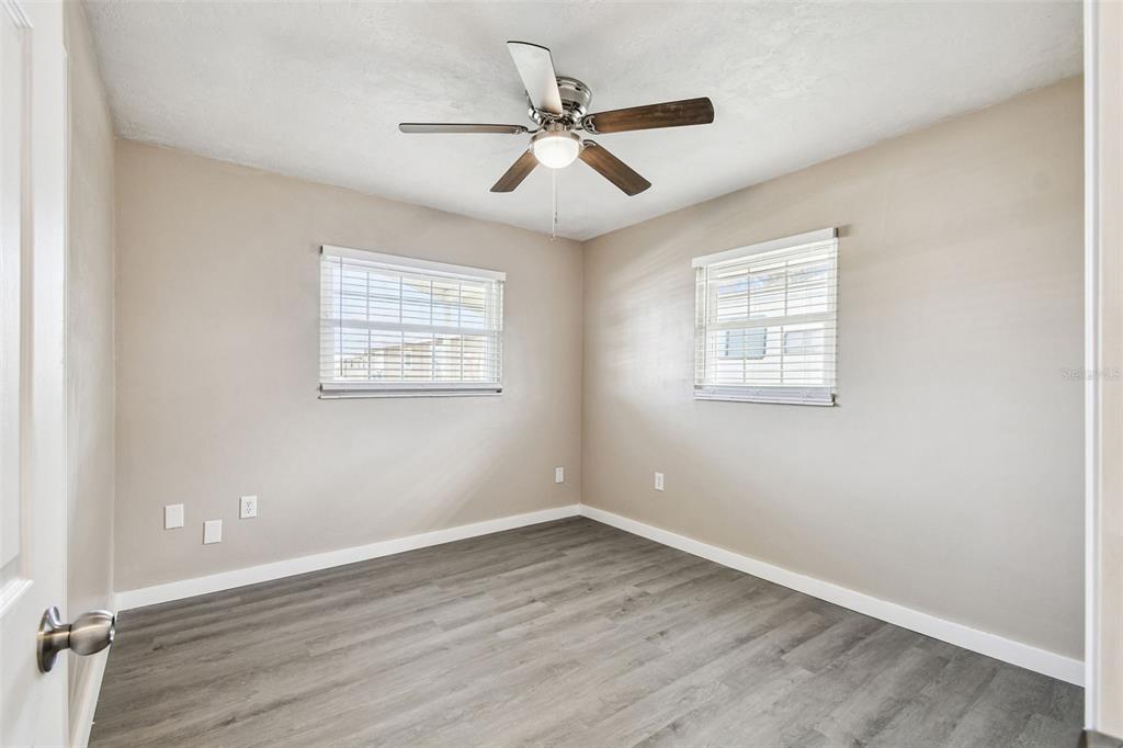 337 4th Street West, Unit A Palmetto, FL 34221 - Photo 6 of 25 an empty room with wooden floor ceiling fan and windows