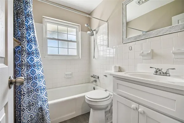 a bathroom with a bathtub shower sink vanity and toilet