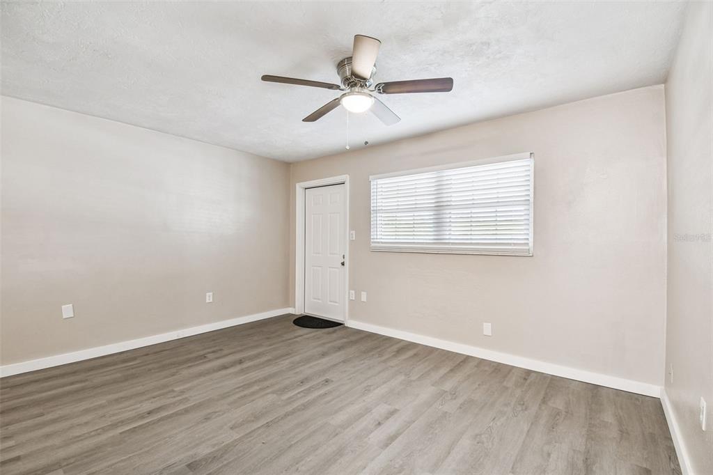 337 4th Street West, Unit A Palmetto, FL 34221 - Photo 8 of 25 an empty room with wooden floor ceiling fan and windows