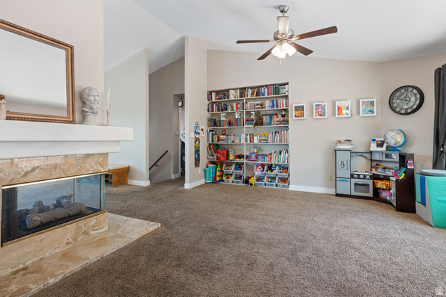 790 East Fiddlers Canyon Road Cedar City, UT 84721 - Photo 8 of 35 Spacious living area featuring a corner fireplace with stone surround, a built-in shelving unit, a ceiling fan, and vaulted ceilings
