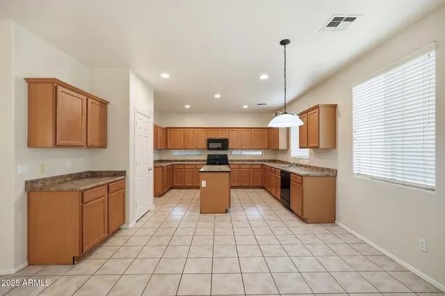 a kitchen with stainless steel appliances granite countertop a stove top oven a sink dishwasher and a refrigerator