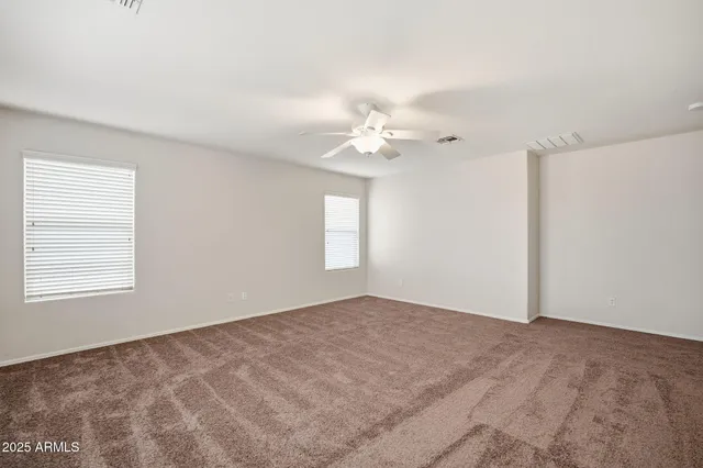 an empty room with a chandelier fan