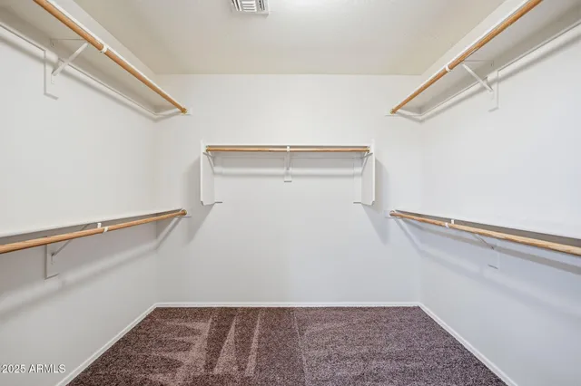 an empty room with closet and a ceiling fan