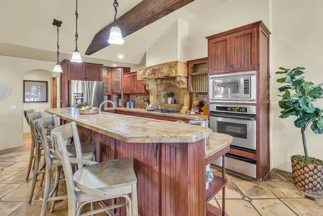 a dining table with chairs and kitchen view