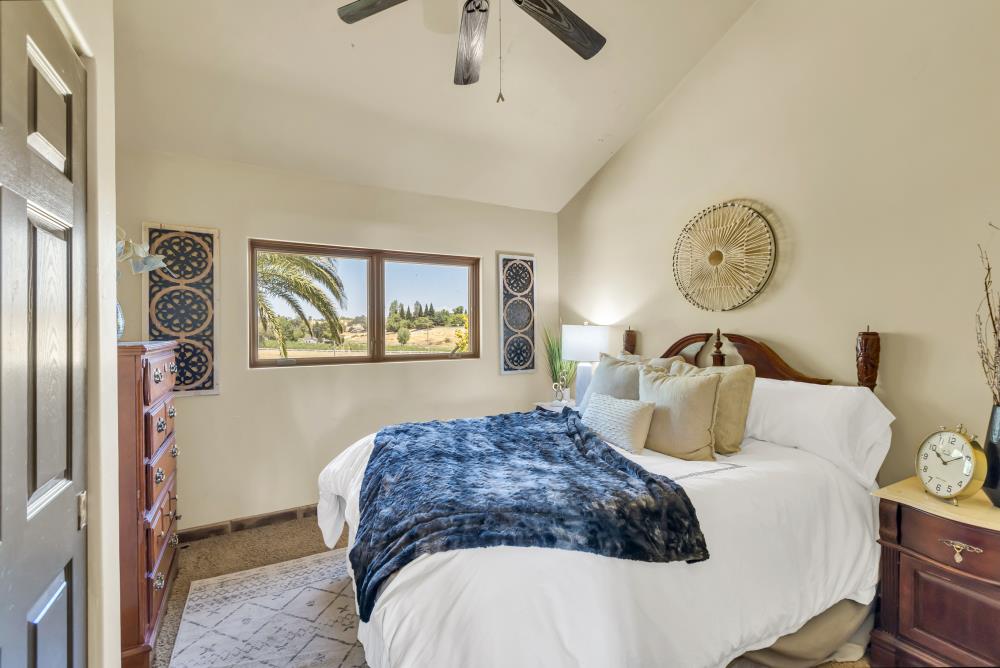 6780 McCourtney Road Lincoln, CA 95648 - Photo 21 of 37 a bedroom with a bed and a chandelier