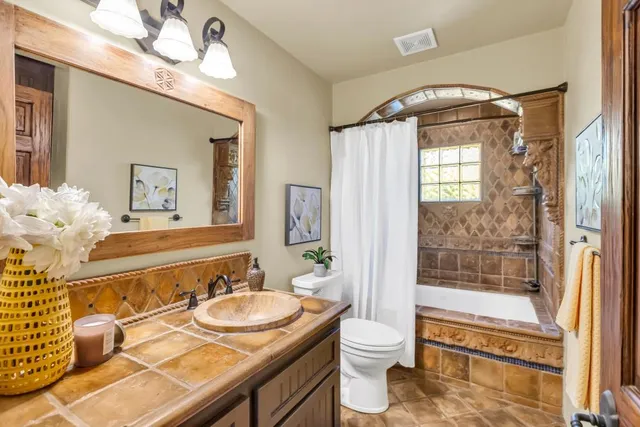 a bathroom with a granite countertop sink a mirror and a shower