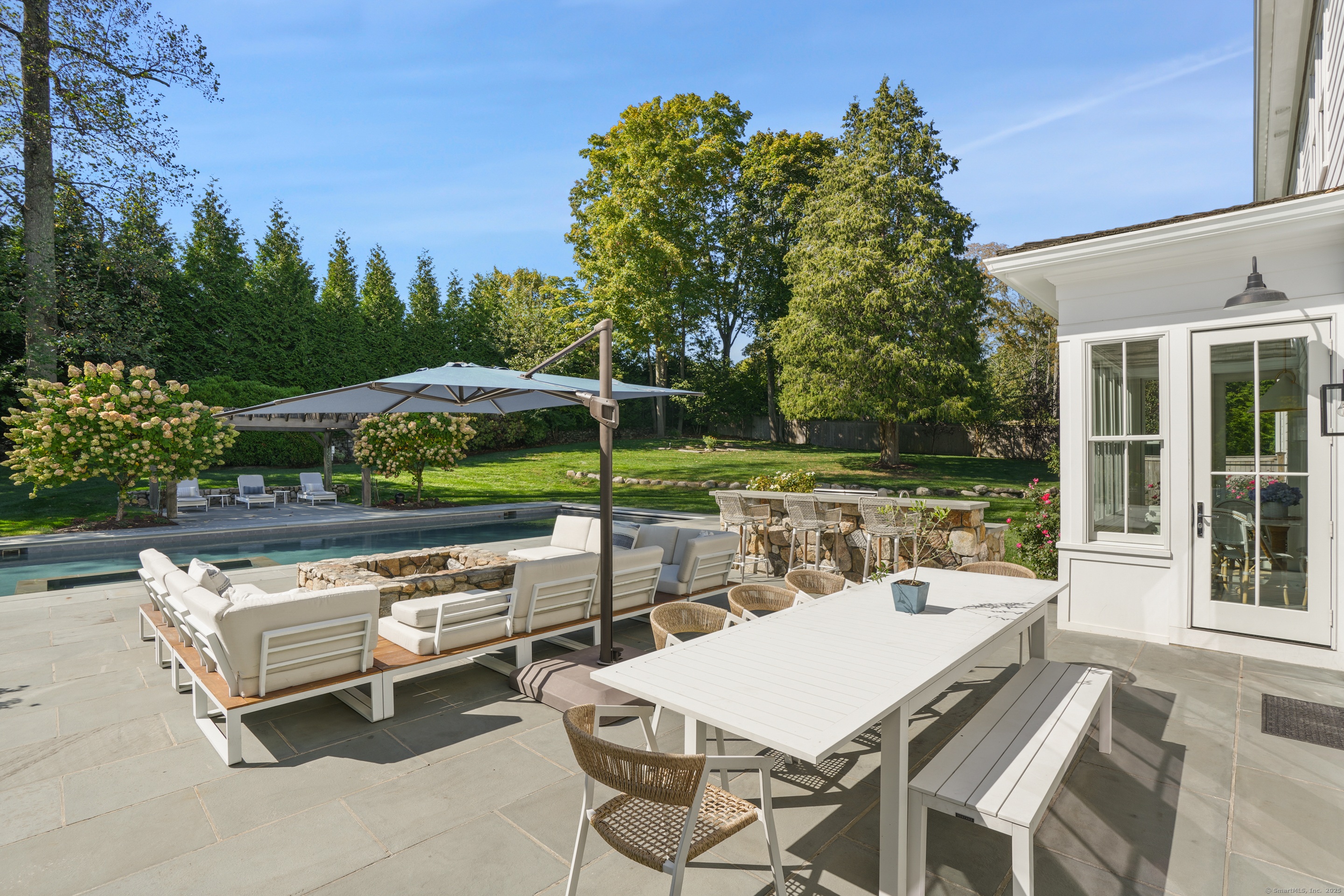 9 Burr Farms Road Westport, CT 06880 - Photo 34 of 40 a view of a patio with a table chairs and a backyard